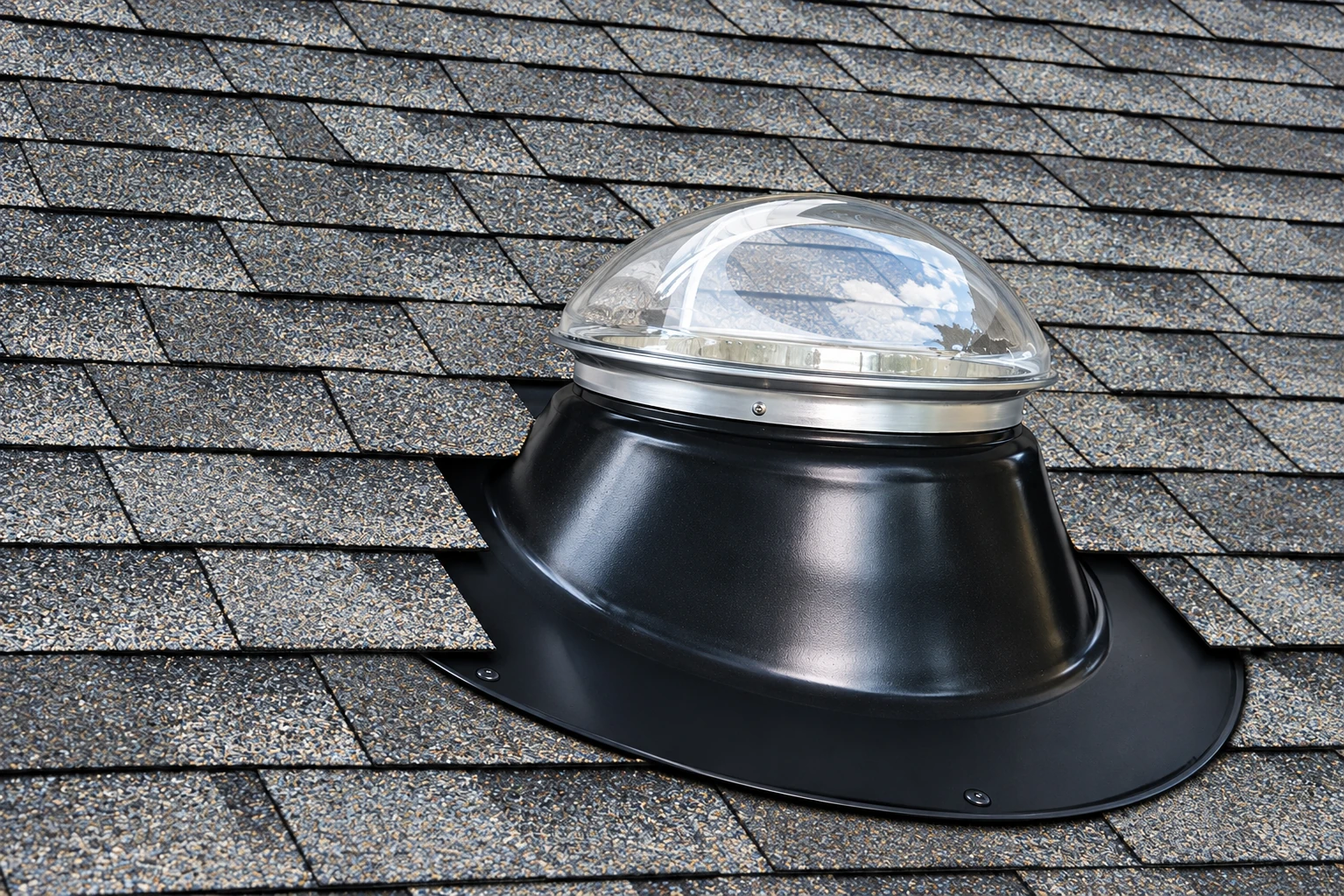 Residential sun tube installed on an asphalt shingle roof