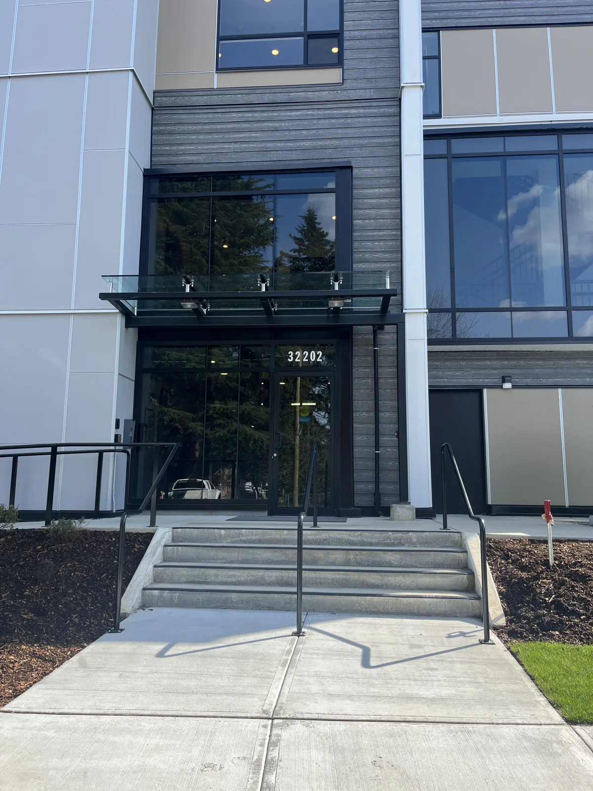 Front view of the Abbotsford residential entrance, curtain wall and glass canopy.