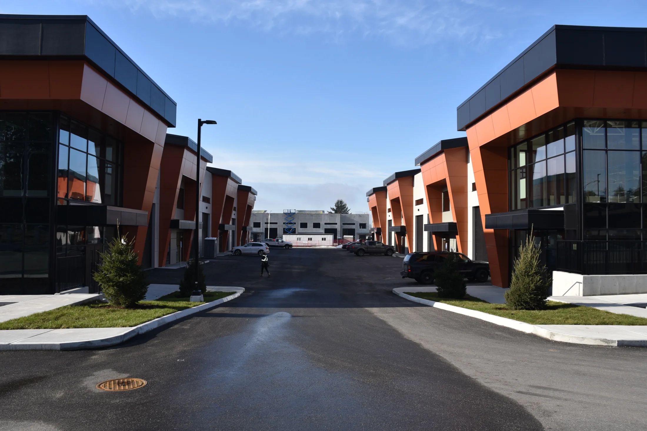 Diverse Building — Corner glazing punctuates a sequence of industrial buildings with warm-toned panels and dark trim.
