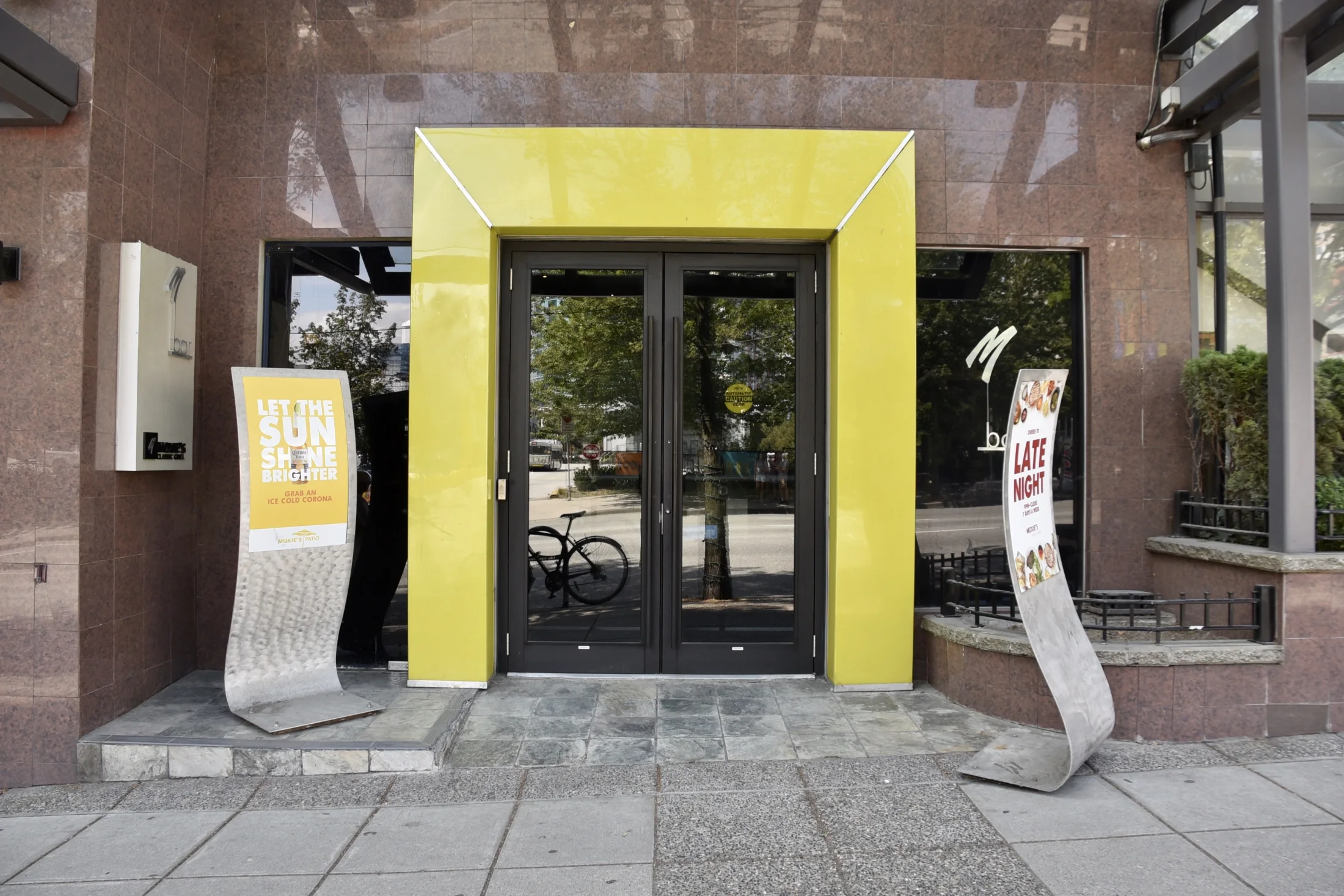 Moxies Restaurant — A glazed double-door entrance creates a clear arrival point within the restaurant’s stone frontage.