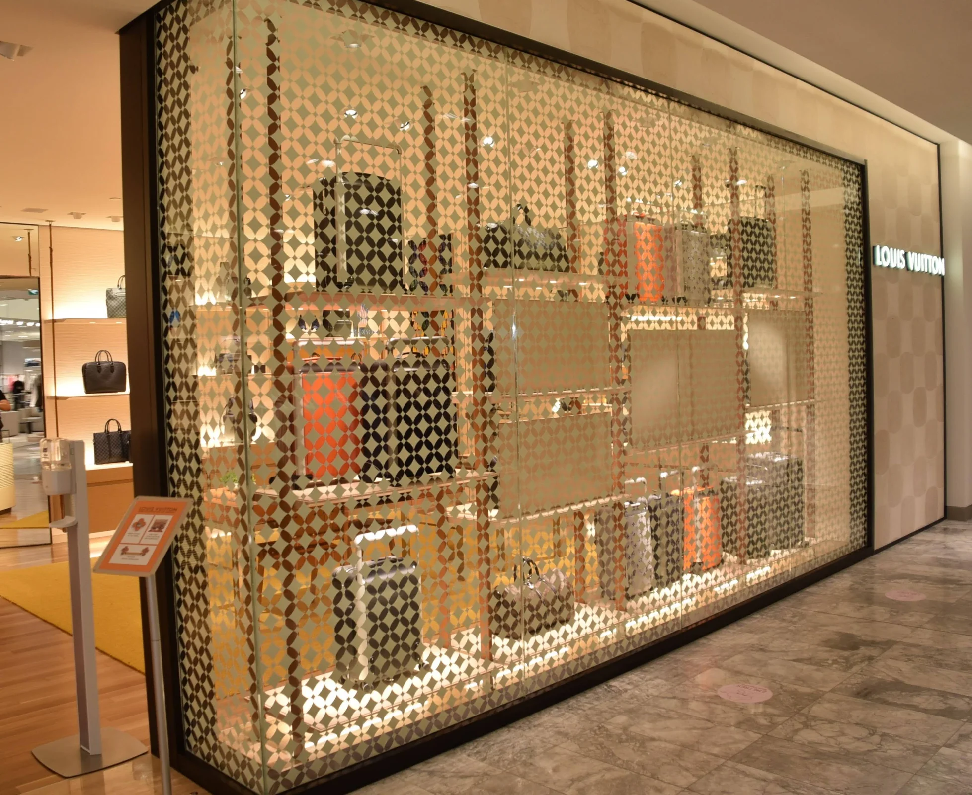 Louis Vuitton Interior Glazing — A glazed boutique frontage combines product visibility with a patterned retail display.